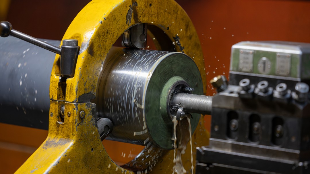 Eine Edelstahlwalze erhält auf der Drehmaschine eine gleichmäßige, präzise definierte Oberfläche.