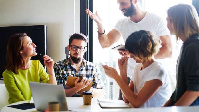  Workers discussing at a desk