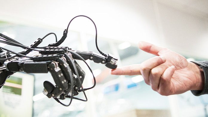 Ein Roboterzeigefinger berührt einen Zeigefinger