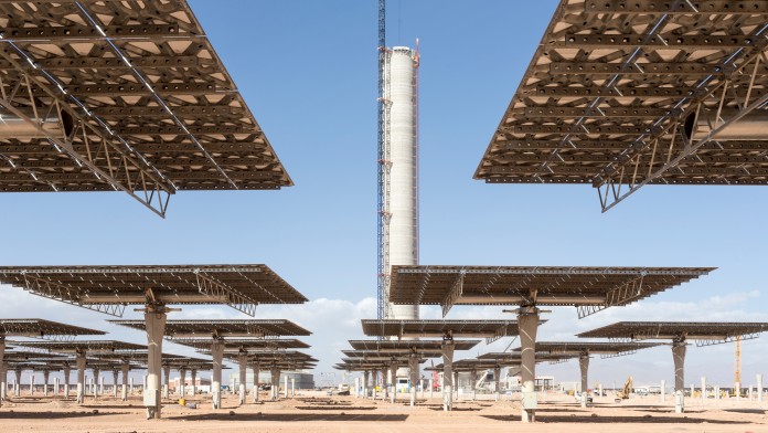 Blick von unten auf Solarpaneele und einen Solarturm