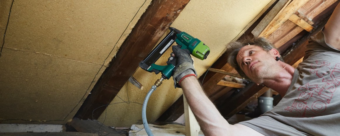 Bauarbeiter reißt Mauer zur Sanierung des Fachwerkhauses ab
