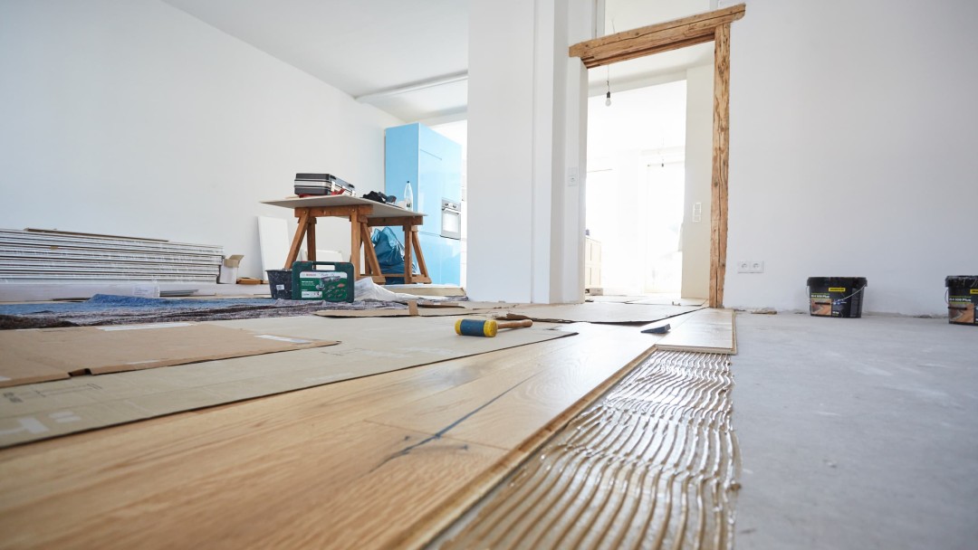 Blick in ein Zimmer, wo der Fußboden gerade neu verlegt wird