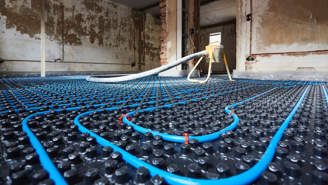 EIne Fußbodenheizung wird installiert, die Schläuche sind auf dem Boden verlegt 