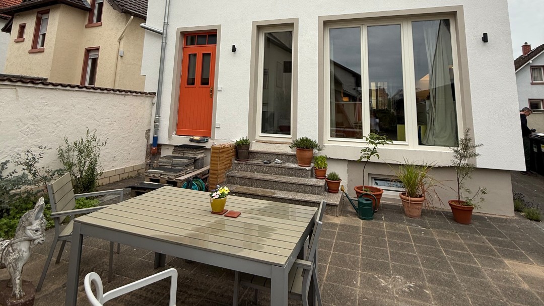 Ansicht eines Hauses mit Terasse mit einem Tisch und einem Stuhl darauf