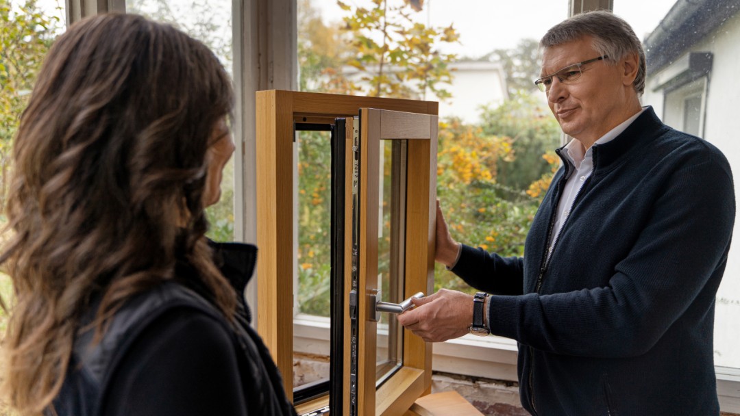 Fachunternehmer und Energieeffizienz-Expertin sehen sich ein Fenster an