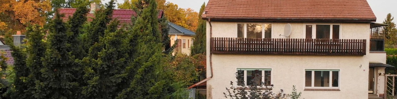 Frontansicht eines alten Einfamilienhauses mit Garten