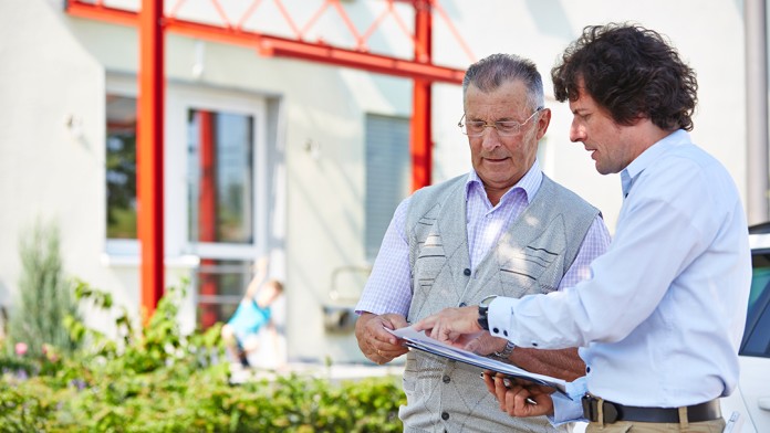 Der Besitzer eines neu gebauten Niedrigenergiehauses im Gespräch mit einem Energieberater 