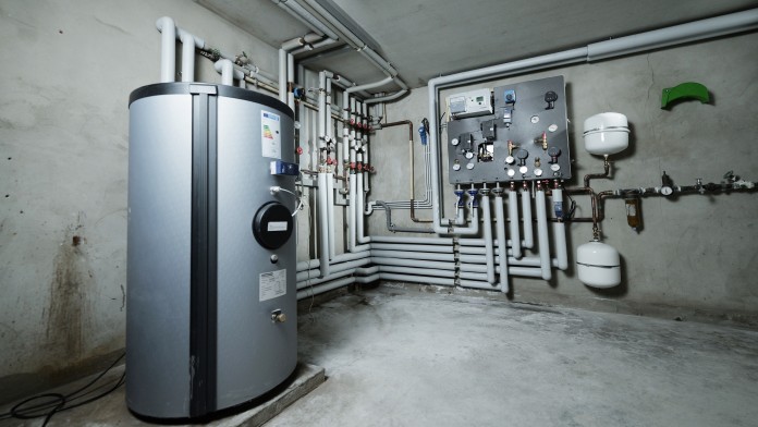 Fernwärmenetzanschluss mit Rohrleitungssystem im Heizraum eines Gebäudes.