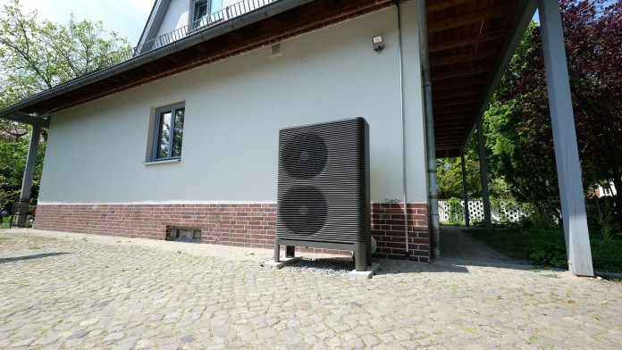 Eine angeschlossene Wärmepumpe befindet sich vor einem Einfamilienhaus.