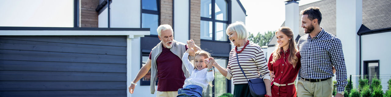 Paar mit Kindern steht auf der Baustelle des neuen Hauses