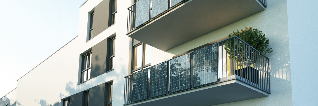 Ein neugebautes Mehrfamilienhaus mit Photovoltaik-Anlagen an den Balkonen.