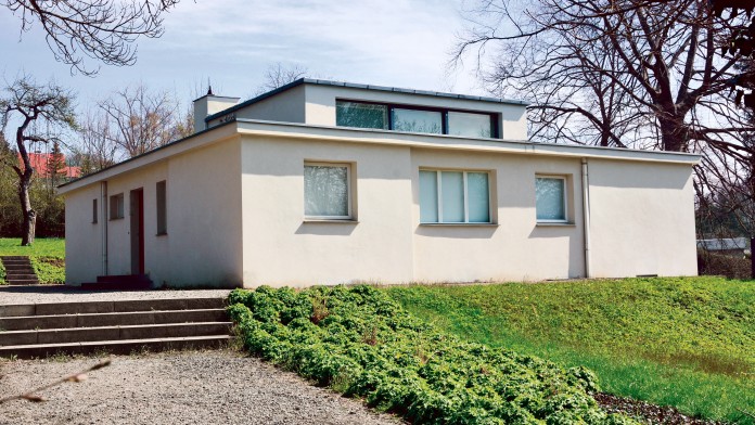EIn Haus im Bauhaus-Stil mit grünem Vorgarten