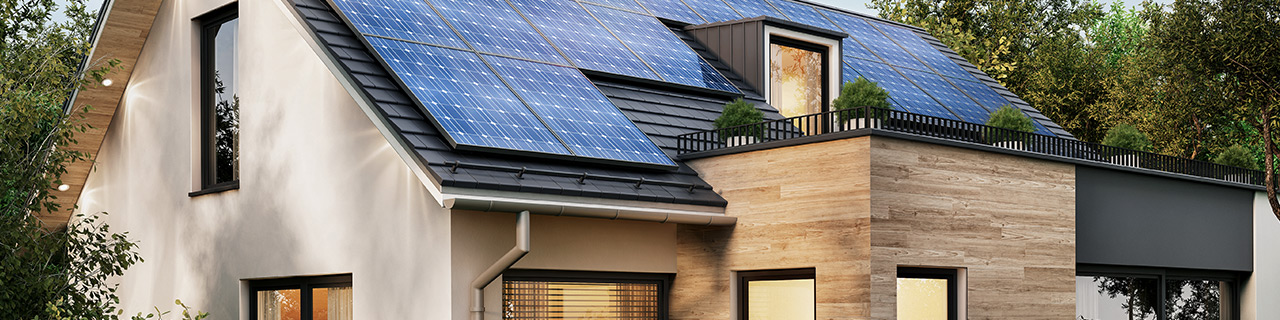 Sonnenkollektoren auf dem Giebeldach eines modernen Hauses mit Dachterasse
