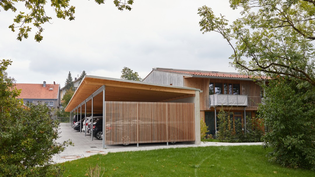 Hölzernes Carport, unter dem mehrere Autos stehen