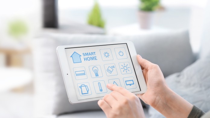 Frau bedient eine Smart Home App auf ihrem Tablet