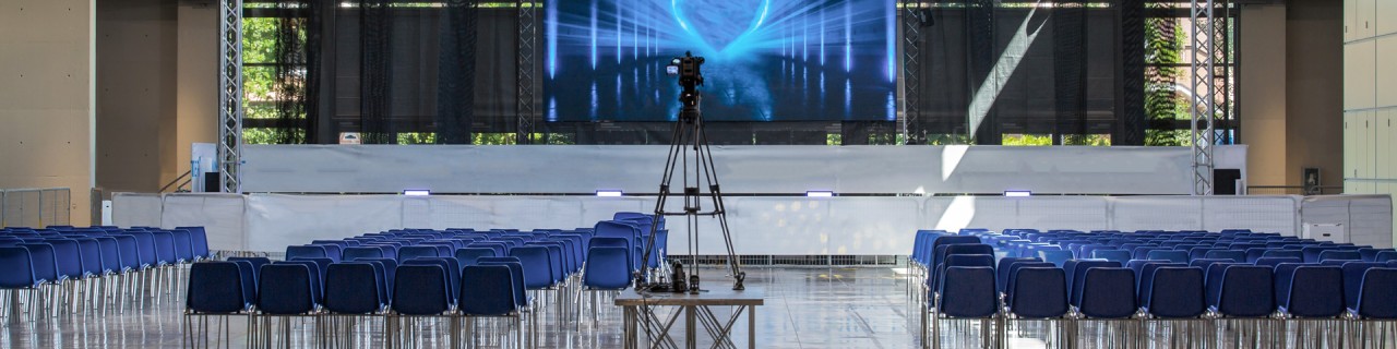 Leerer Konferenzraum, ausgestattet mit Bühne, Licht, Stühlen und professioneller Kamera