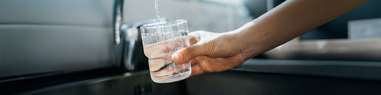 ein Glas wird mit Leitungswasser gefüllt