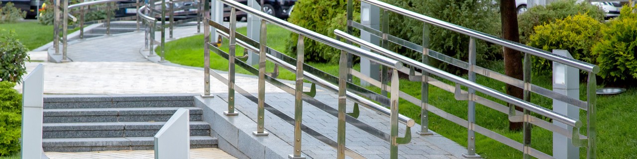 Steinrampe mit Eisengeländer in einem Stadtpark für barrierefreie Mobilität