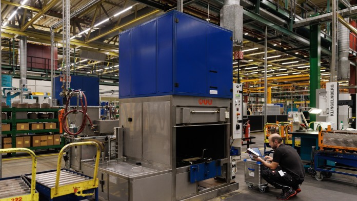 Ein Mann bringt Messgeräte an einer Industriewaschmaschine an