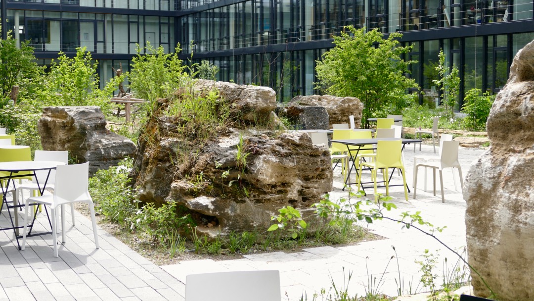 Tische und Stühle im naturnahen Innenhof von Kärcher