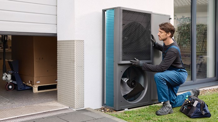 Ein Handwerker installiert eine Wärmepumpe