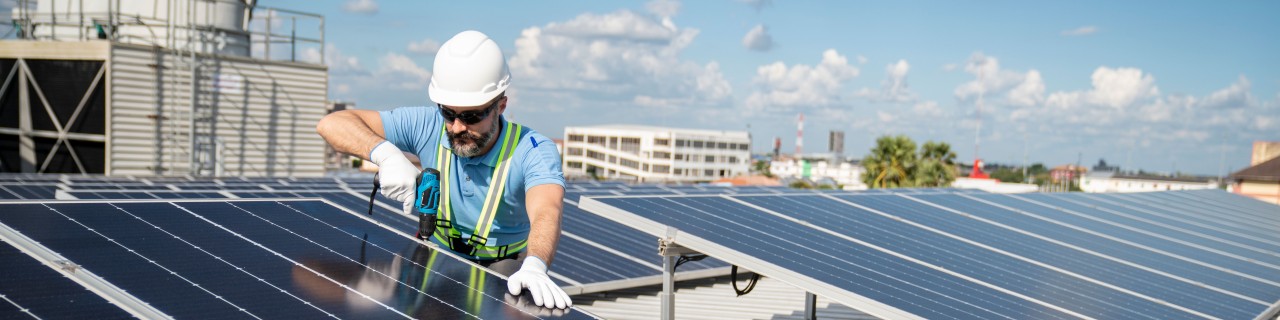 Ein Handwerker installiert eine Photovoltaikanalage