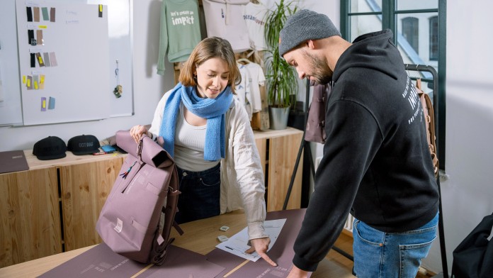 Der GOTBAG-Gründer und eine Mitarbeiterin arbeiten gemeinsam einem neuen Rucksack