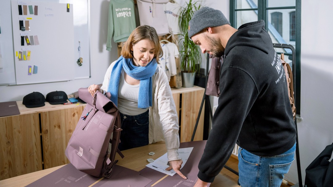 Der GOTBAG-Gründer und eine Mitarbeiterin arbeiten gemeinsam einem neuen Rucksack