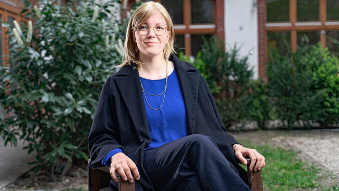 Eine Frau sitzt auf einem Stuhl in einem Garten