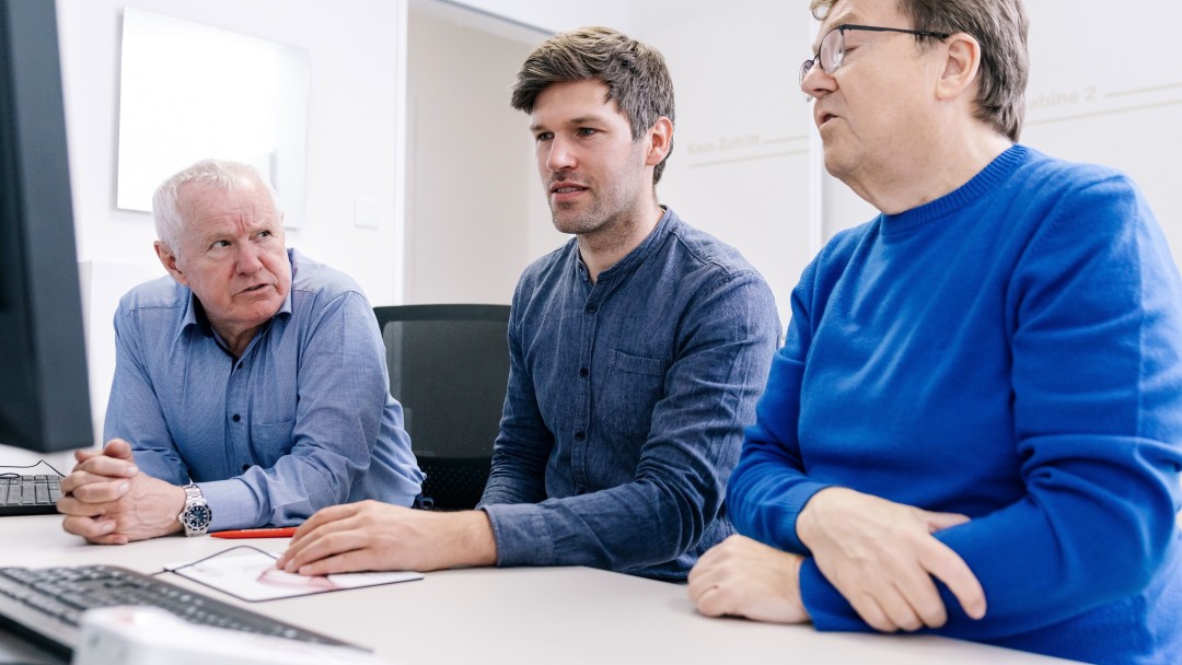 Ärzteteam bespricht gemeinsam MRT-Aufnahmen am Computer