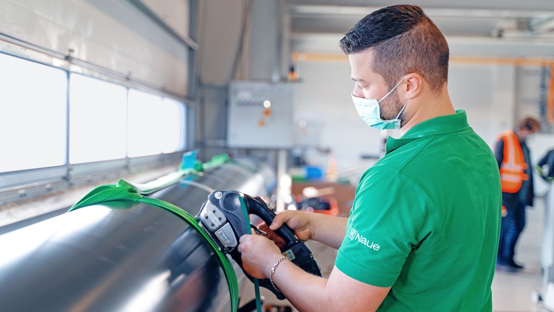 Ein Mitarbeiter der Naue GmbH arbeitet in einer Fabrikhalle