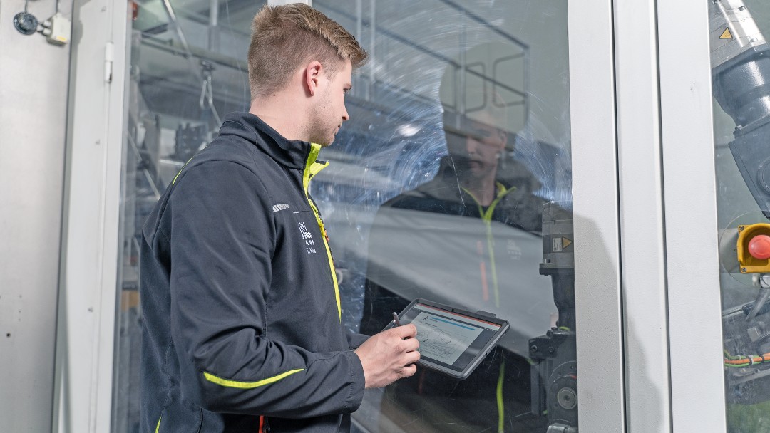 Ein Mitarbeiter der Naue GmbH bedient eine Maschine per Tablet