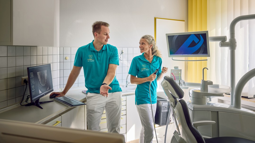 Michael Feulner und eine Zahnmedizinische Fachassistentin bei der Begutachtung einer Röntgenaufnahme