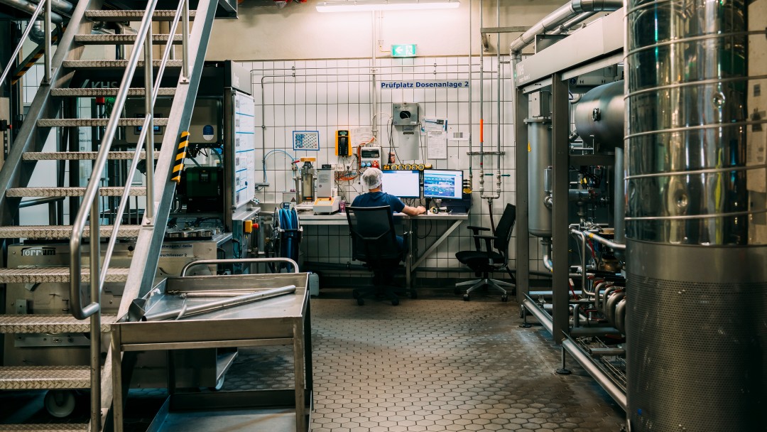 Mann am Computer in der Abfüllhalle der Rhodius Mineralquellen