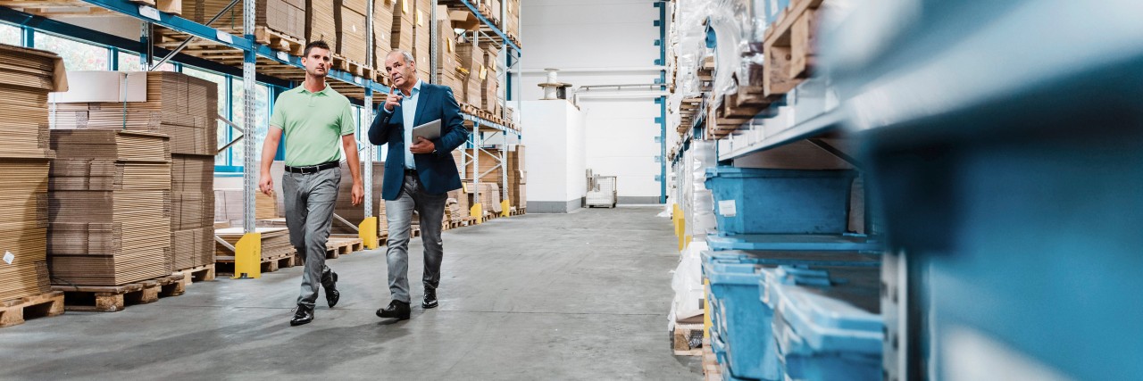 Mitarbeiter laufen durch eine Lagerhalle