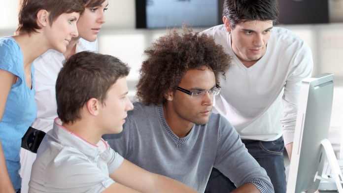 A group of young people are looking at a screen