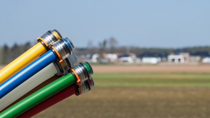 Farbige Leerrohre für Breitbandkabel vor einer ländlichen Gegend