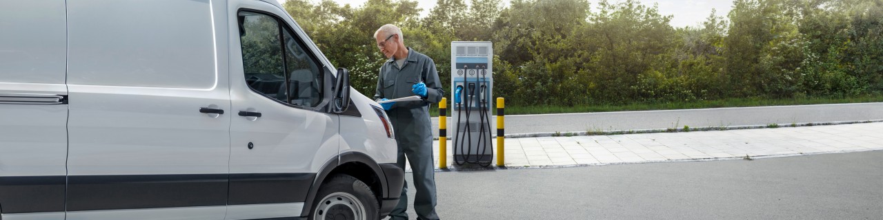 Mann lädt seinen Transporter an einer Ladestation