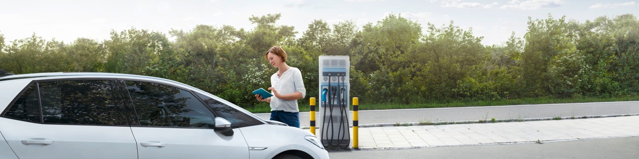 Frau lädt ihren PKW an einer Ladestation