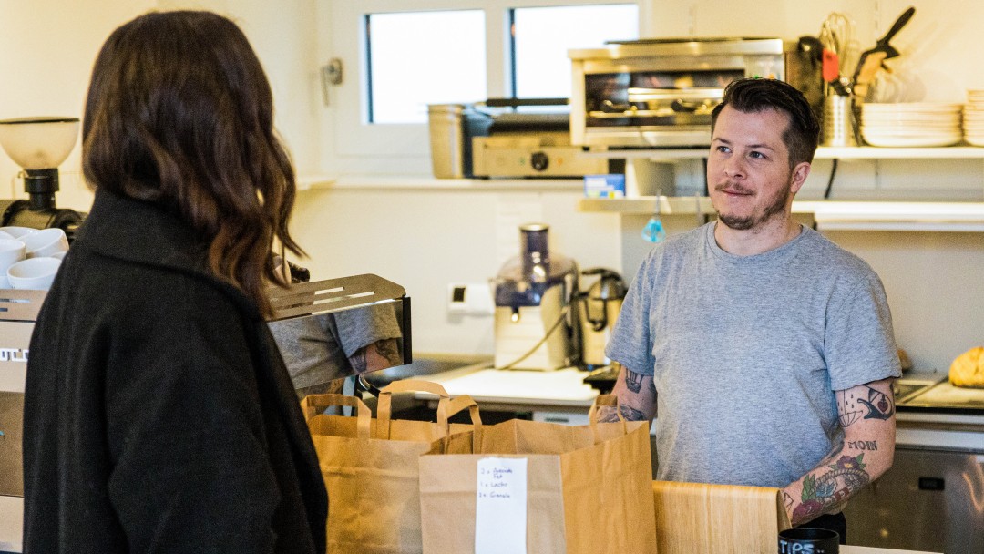 Marie Kotte und Tristian Garret unterhalten sich über den Tresen ihres Cafés hinweg