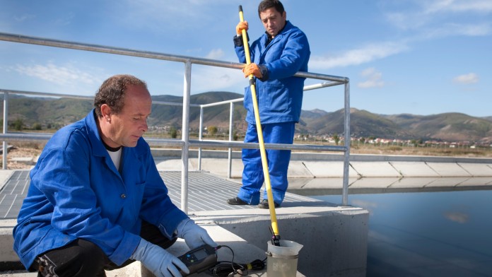 Mitarbeiter prüfen die Wasserqualität in einer Kläranlage