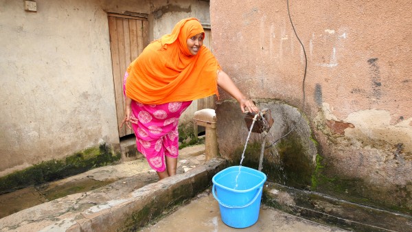 Frau an öffentlichen Wasserhahn in Uganda
