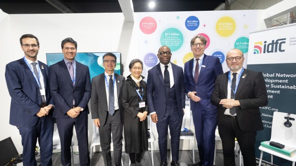 Der Vorstandsvorsitzende der KfW redet während einer Gesprächsrunde auf der COP 29