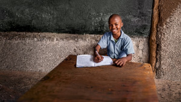 Junge aus Afrika vor Schultafel