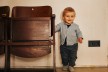 A toddler leaning against an old theater chair