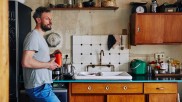 Lutz-Rainer Müller lehnt am Kühlschrank in seiner Küche