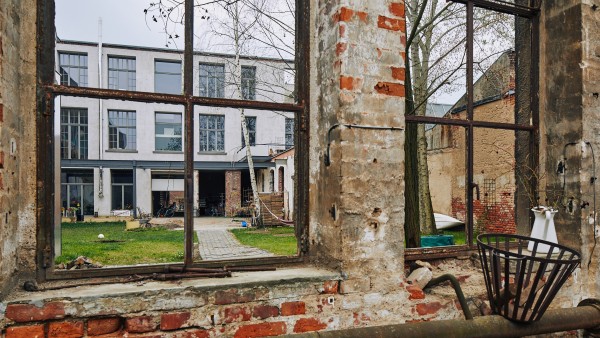 Blick aus der Ruine durchs Fenster auf den Innenhof und die Rückseite des Hinterhauses