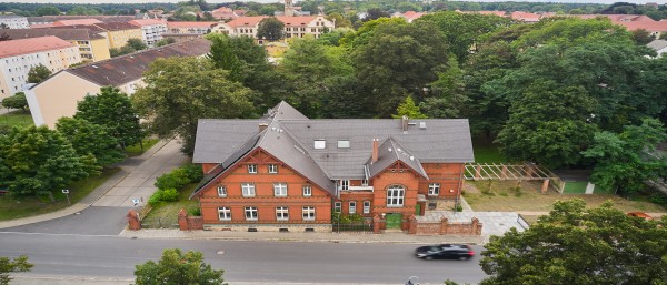 Luftaufnahme eines großen, roten Hauses mit einem schwarzen Dach