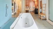 unter der Treppe eine kleines Bad mit Wanne, zwei Becken und Sauna.