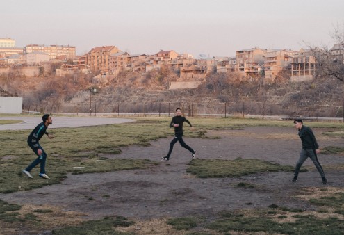  Jugendliche spielen im Park des Tumo Center Frisbee